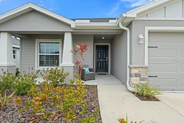 6708 162nd Pl E, Parrish, FL 34219 - doorway to property with covered porch, a garage, stucco siding, and stone siding