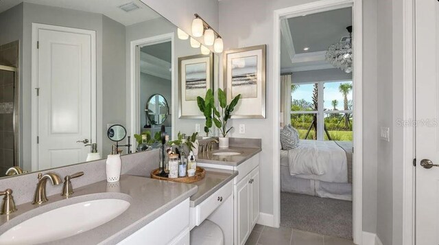 ensuite bathroom featuring crown molding, tile patterned flooring, double vanity, baseboards, and tiled shower