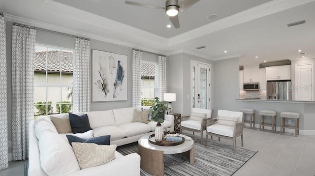living area featuring healthy amount of natural light, ceiling fan, recessed lighting, a raised ceiling, and ornamental molding