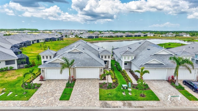view of front of home with a residential view, a water view, stucco siding, and decorative driveway