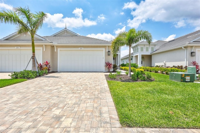 ranch-style house with a front lawn, an attached garage, decorative driveway, and stucco siding