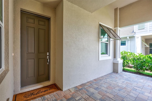 doorway to property featuring stucco siding