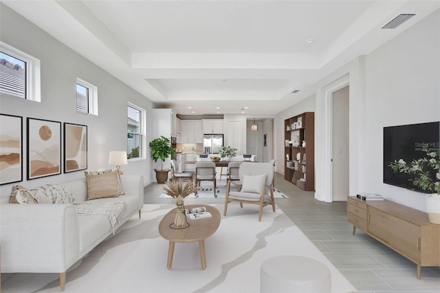 living area with a tray ceiling and recessed lighting