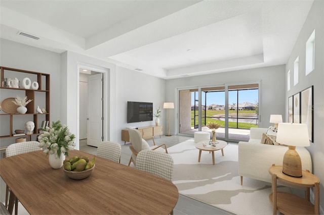 living area with a tray ceiling and light tile patterned floors