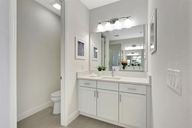 bathroom with toilet, a shower, baseboards, tile patterned floors, and vanity