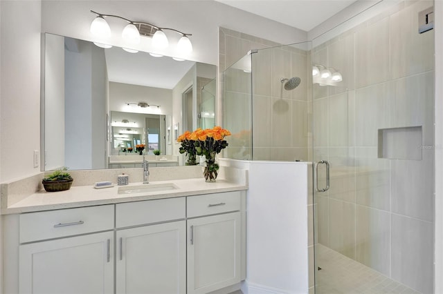 bathroom with a shower stall and vanity