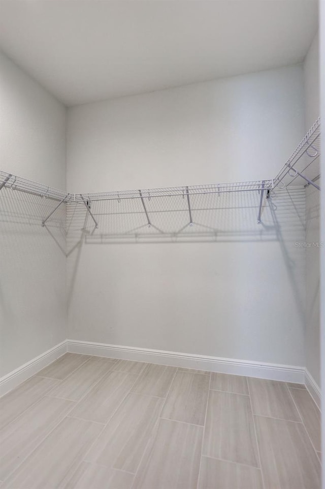 walk in closet with wood tiled floors