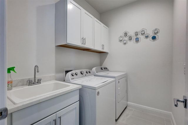 washroom featuring washer and dryer, cabinet space, baseboards, and light tile patterned floors