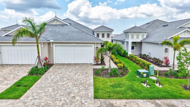 view of front facade featuring a garage, stucco siding, driveway, and a front yard
