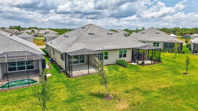 back of house with a patio area, a lanai, an outdoor pool, and a yard