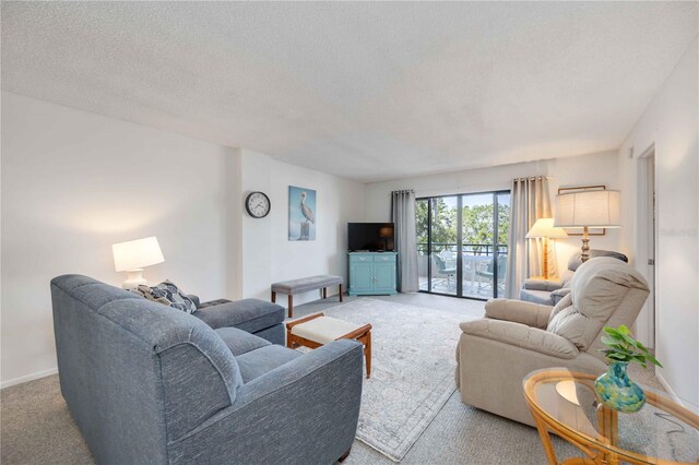 carpeted living room featuring a textured ceiling and baseboards