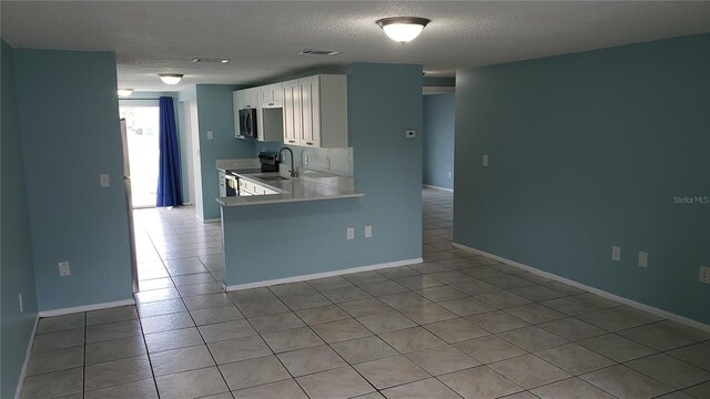 4304 78th St W Unit 4304, Bradenton, FL 34209 - kitchen featuring stainless steel appliances, white cabinets, a textured ceiling, light tile patterned flooring, and light countertops