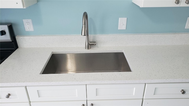 4304 78th St W Unit 4304, Bradenton, FL 34209 - kitchen view of a sink, white cabinetry, and light stone countertops