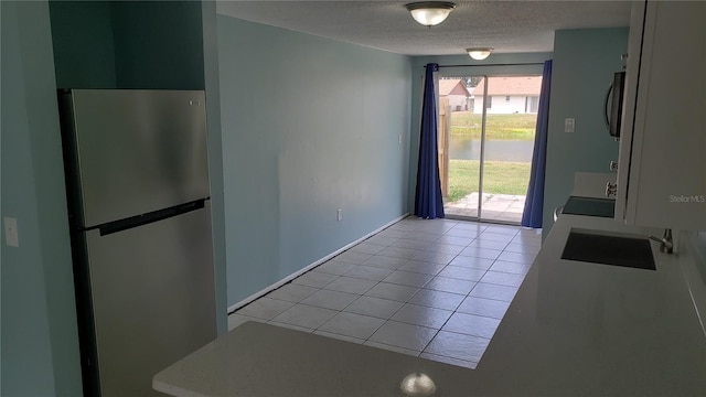 4304 78th St W Unit 4304, Bradenton, FL 34209 - unfurnished dining area with a sink, light tile patterned flooring, and a textured ceiling