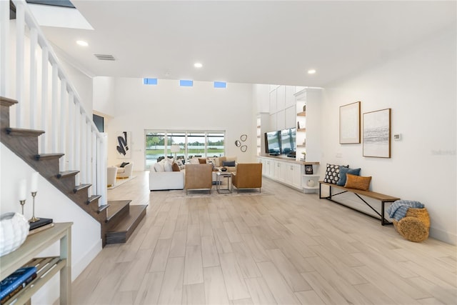 foyer featuring stairway, light wood finished floors, recessed lighting, and baseboards