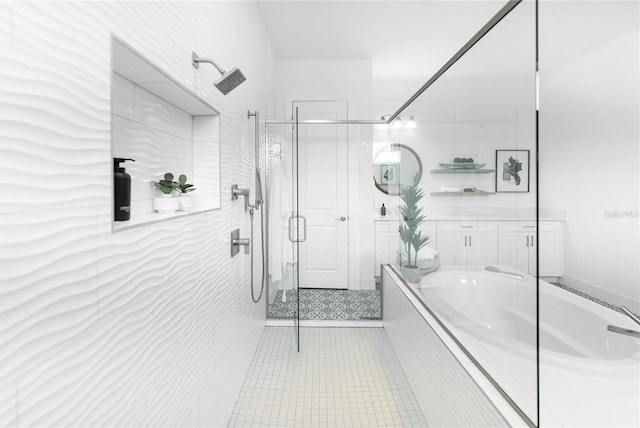 bathroom featuring a bath, a shower stall, and tile patterned flooring