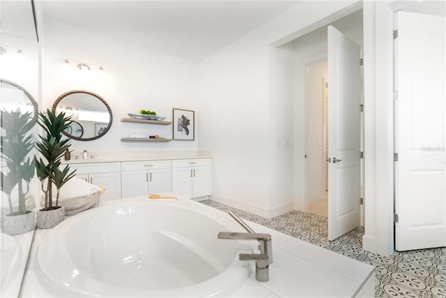 full bathroom featuring a bath, vanity, and baseboards