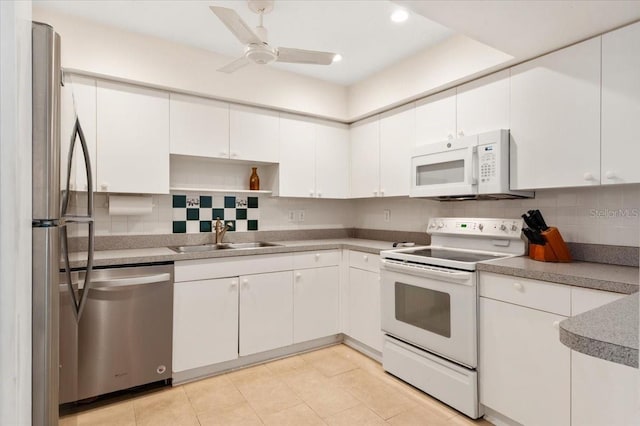 1629 Pelican Cove Rd Unit 138A, Sarasota, FL 34231 - kitchen featuring appliances with stainless steel finishes, a sink, white cabinetry, tasteful backsplash, and recessed lighting