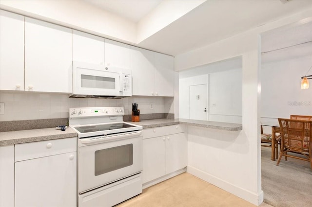 1629 Pelican Cove Rd Unit 138A, Sarasota, FL 34231 - kitchen featuring white appliances, white cabinets, decorative backsplash, and light countertops