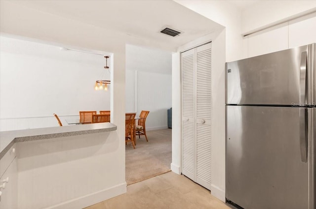 1629 Pelican Cove Rd Unit 138A, Sarasota, FL 34231 - kitchen with freestanding refrigerator, white cabinetry, baseboards, light carpet, and modern cabinets
