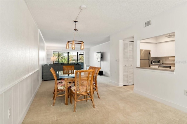 1629 Pelican Cove Rd Unit 138A, Sarasota, FL 34231 - dining room featuring light carpet, a chandelier, and baseboards