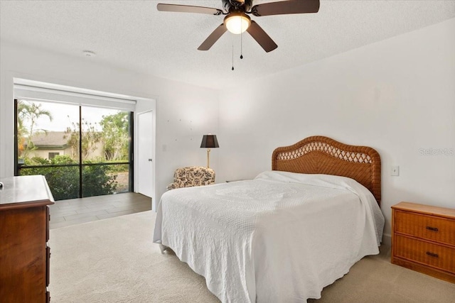 1629 Pelican Cove Rd Unit 138A, Sarasota, FL 34231 - bedroom with light colored carpet, access to exterior, ceiling fan, and a textured ceiling