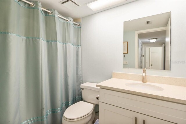 1629 Pelican Cove Rd Unit 138A, Sarasota, FL 34231 - bathroom featuring toilet, vanity, and curtained shower