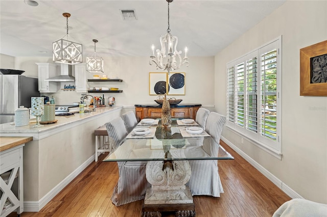 6402 23rd Avenue Dr W, Bradenton, FL 34209 - dining space featuring a chandelier, wood-type flooring, and baseboards