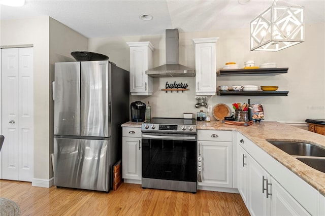 6402 23rd Avenue Dr W, Bradenton, FL 34209 - kitchen with stainless steel appliances, wall chimney exhaust hood, light wood-style floors, white cabinetry, and open shelves