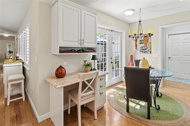6402 23rd Avenue Dr W, Bradenton, FL 34209 - dining space with light wood finished floors, a chandelier, and baseboards