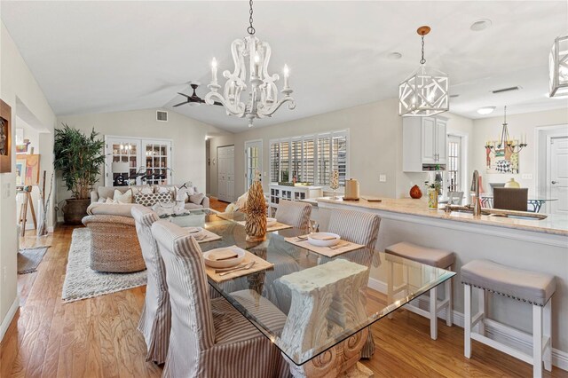 6402 23rd Avenue Dr W, Bradenton, FL 34209 - dining area featuring a chandelier, light wood-style floors, vaulted ceiling, and baseboards