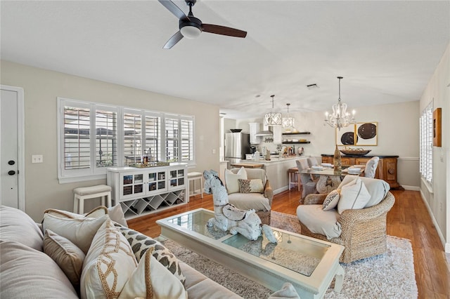 6402 23rd Avenue Dr W, Bradenton, FL 34209 - living room with ceiling fan, healthy amount of natural light, a chandelier, and light wood-style flooring
