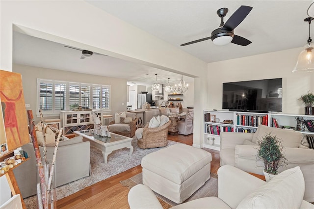 6402 23rd Avenue Dr W, Bradenton, FL 34209 - living area with wood finished floors, a ceiling fan, and a chandelier