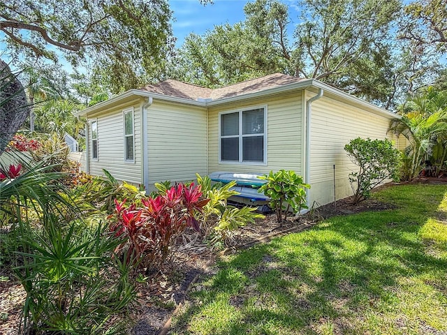 6402 23rd Avenue Dr W, Bradenton, FL 34209 - view of side of home with a yard and roof with shingles