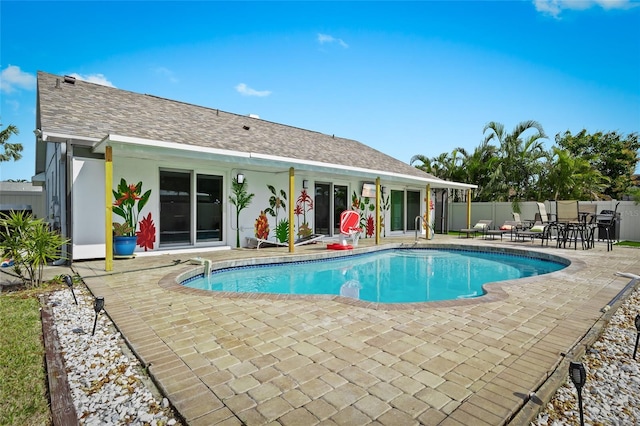 view of swimming pool featuring a patio area and fence