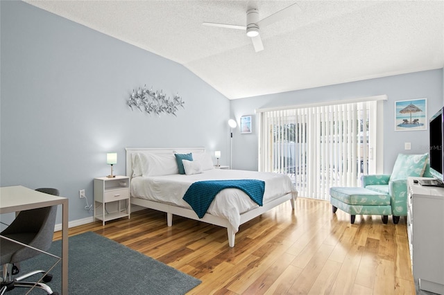bedroom featuring access to outside, lofted ceiling, a textured ceiling, light wood-style flooring, and ceiling fan