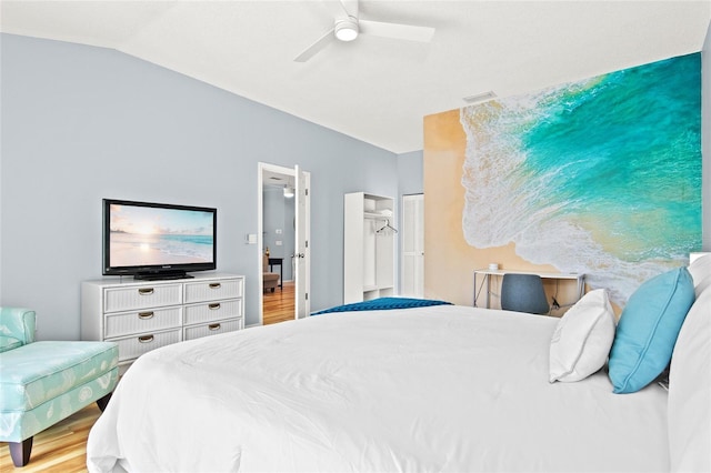bedroom with wood finished floors, a ceiling fan, and lofted ceiling
