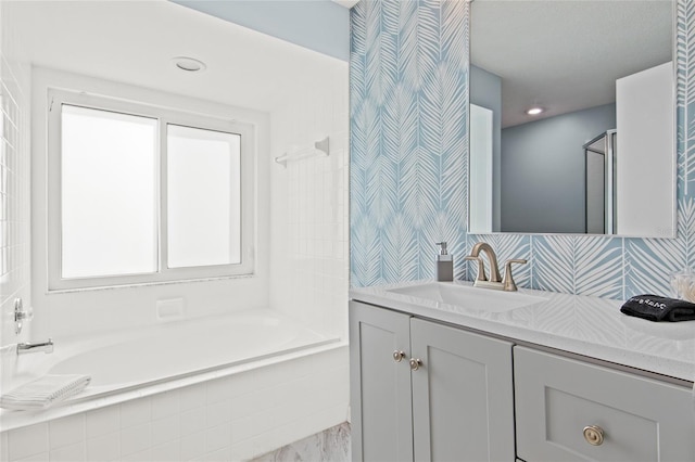 bathroom with vanity, decorative backsplash, and tiled shower / bath