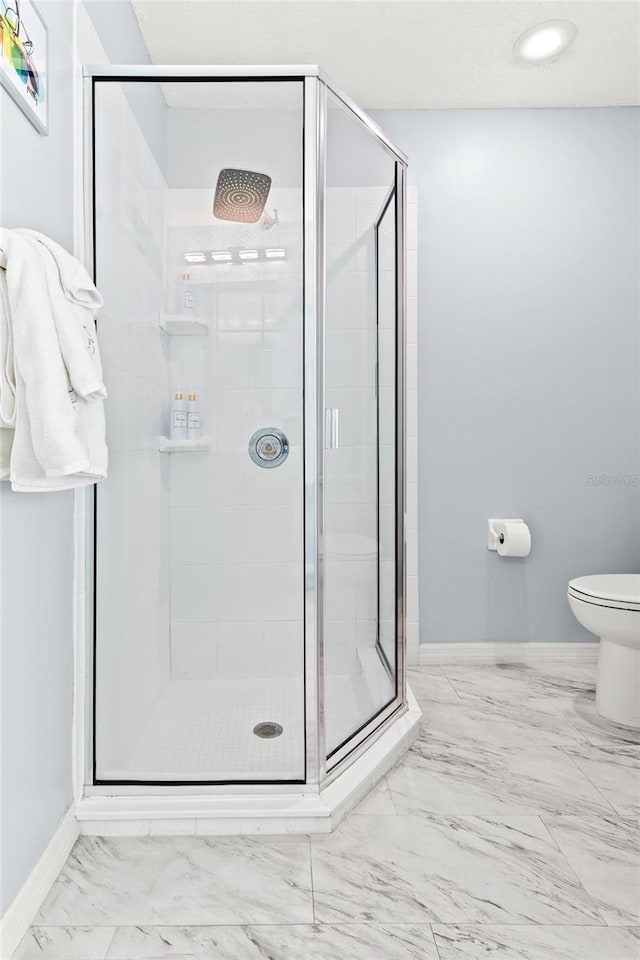 bathroom featuring baseboards, marble finish flooring, a shower stall, and recessed lighting