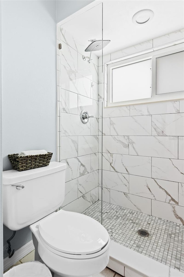 bathroom featuring toilet and tiled shower