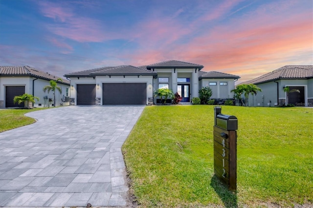 4312 Vasco St, Punta Gorda, FL 33950 - prairie-style house with decorative driveway, a garage, a yard, stucco siding, and a tile roof