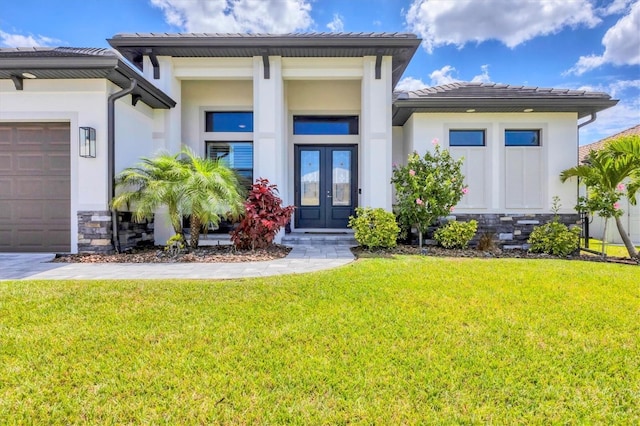 4312 Vasco St, Punta Gorda, FL 33950 - view of exterior entry featuring french doors, stucco siding, a lawn, and a garage