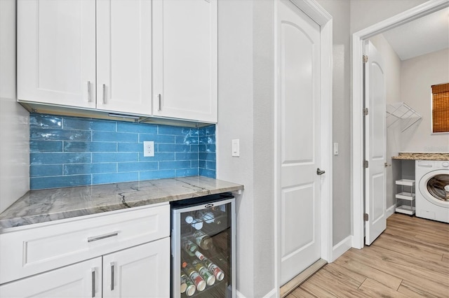 4312 Vasco St, Punta Gorda, FL 33950 - bar with beverage cooler, washer / dryer, backsplash, light wood-type flooring, and baseboards