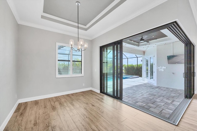 4312 Vasco St, Punta Gorda, FL 33950 - unfurnished dining area with wood finished floors, a tray ceiling, a ceiling fan, a chandelier, and baseboards