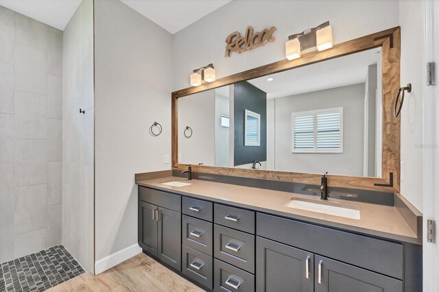 4312 Vasco St, Punta Gorda, FL 33950 - full bathroom with double vanity, baseboards, tiled shower, and wood finished floors