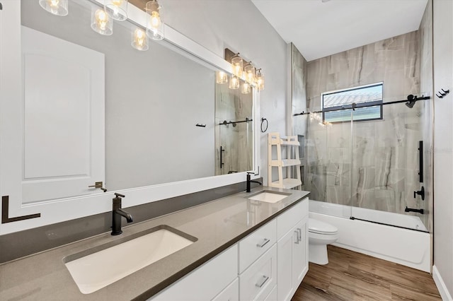 4312 Vasco St, Punta Gorda, FL 33950 - full bath featuring toilet, double vanity, shower / bath combination with glass door, and wood finished floors