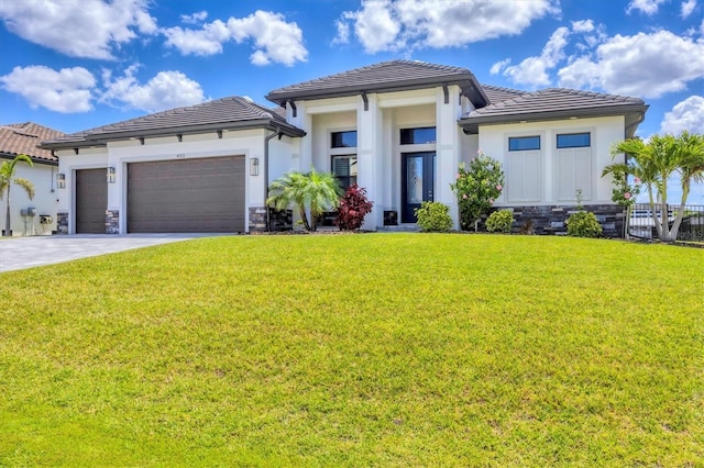 4312 Vasco St, Punta Gorda, FL 33950 - prairie-style house with an attached garage, a tile roof, a front yard, stone siding, and driveway