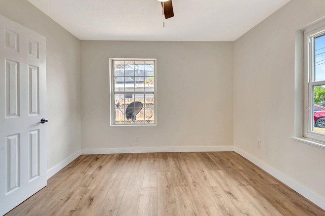 empty room with light wood-type flooring, healthy amount of natural light, baseboards, and a ceiling fan