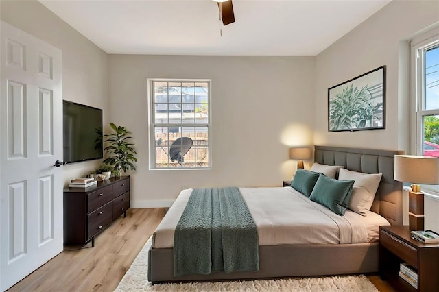 bedroom featuring light wood-style flooring, baseboards, and ceiling fan