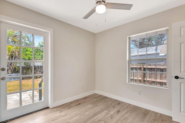 unfurnished room featuring light wood-type flooring, baseboards, and a ceiling fan